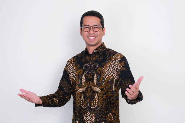 Adult Asian man smiling happy with both hands opened. Welcoming gesture